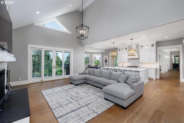 living room with light wood-type flooring, high vaulted ceiling, and plenty of natural light