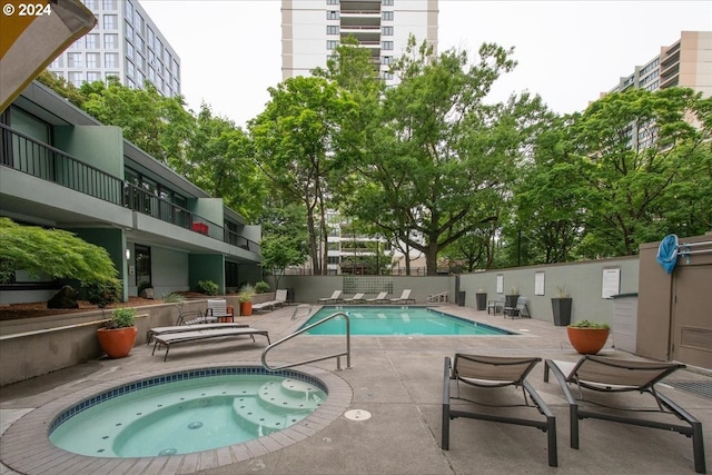 view of pool with a hot tub and a patio area