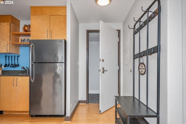 kitchen featuring light hardwood / wood-style flooring, sink, and stainless steel fridge