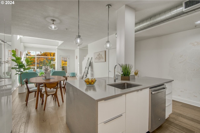 kitchen featuring white cabinetry, dark hardwood / wood-style flooring, hanging light fixtures, sink, and stainless steel dishwasher