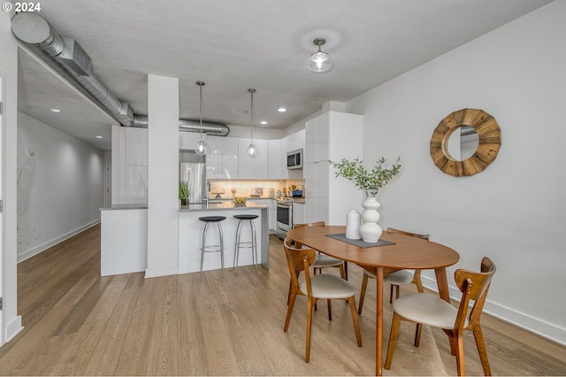 dining space with light hardwood / wood-style floors