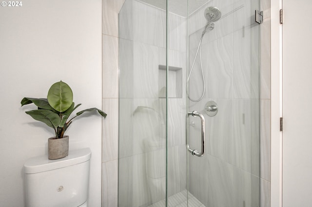 bathroom featuring walk in shower and toilet