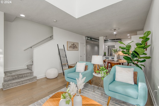 sitting room featuring light wood-type flooring and a textured ceiling