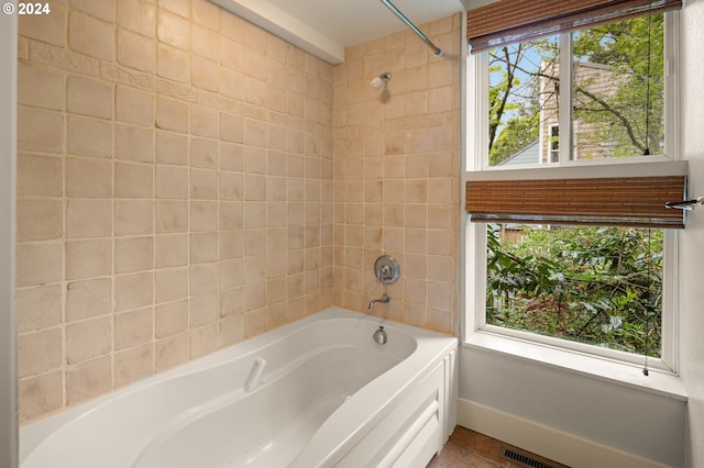 bathroom with tiled shower / bath and a healthy amount of sunlight