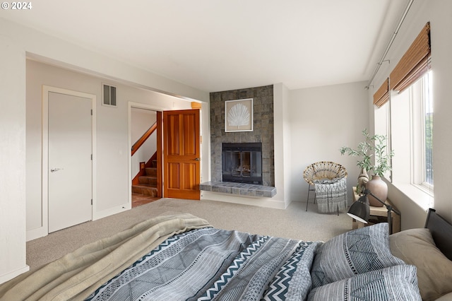 bedroom with a tile fireplace and carpet