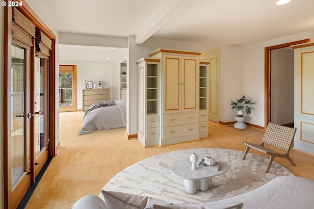 bedroom featuring beamed ceiling and light wood-type flooring