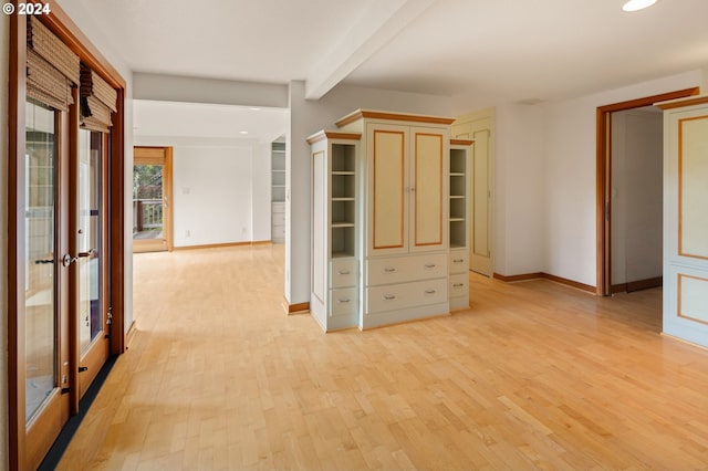 interior space with beam ceiling and light hardwood / wood-style flooring