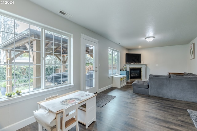 living room featuring visible vents, a high end fireplace, baseboards, and dark wood-style flooring