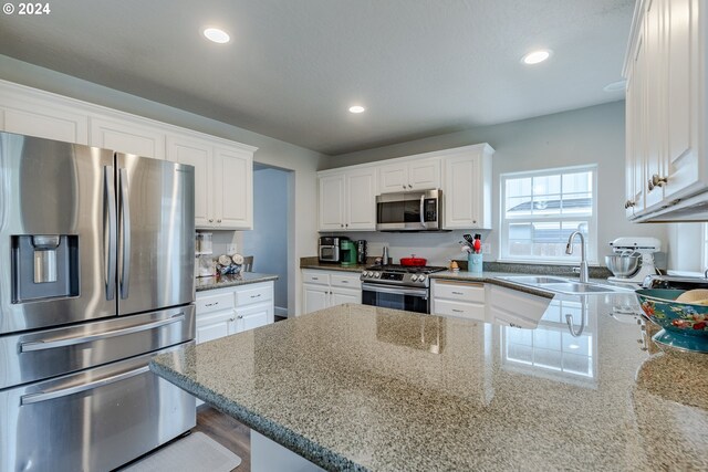 kitchen with a sink, appliances with stainless steel finishes, recessed lighting, and white cabinetry