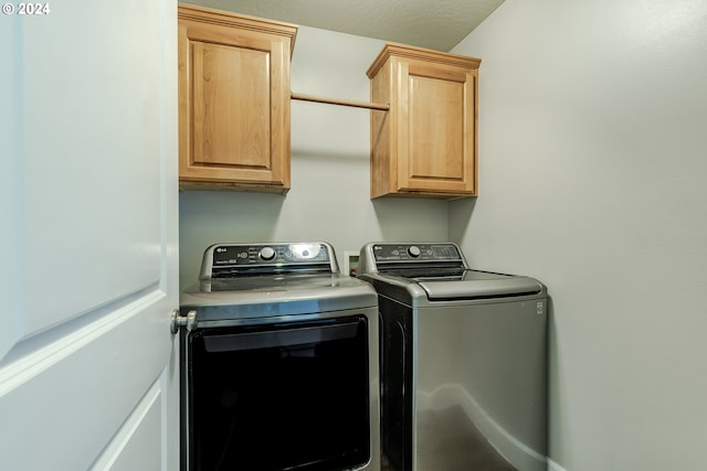 laundry area with independent washer and dryer and cabinets