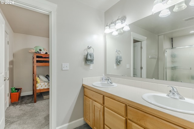 bathroom featuring a shower with door and vanity