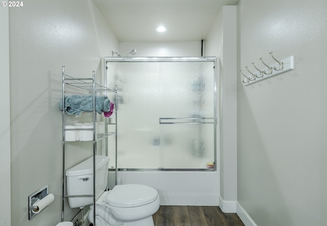 full bathroom with wood finished floors, toilet, baseboards, recessed lighting, and bath / shower combo with glass door
