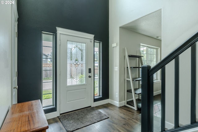 foyer entrance with dark wood-type flooring and plenty of natural light