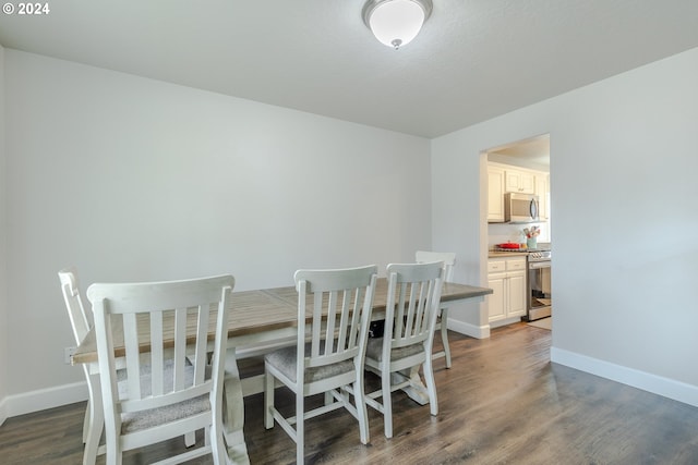 dining space with baseboards and dark wood-style flooring