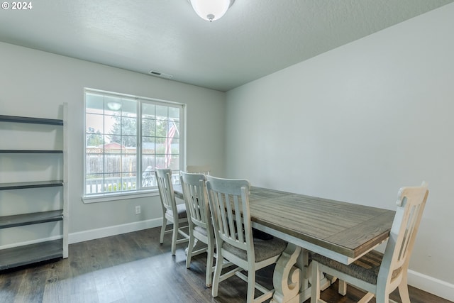 dining area featuring visible vents, baseboards, and wood finished floors