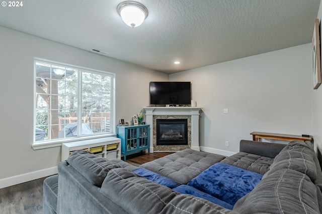 living room featuring a textured ceiling and dark hardwood / wood-style flooring