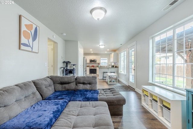 living room featuring a textured ceiling and dark hardwood / wood-style floors