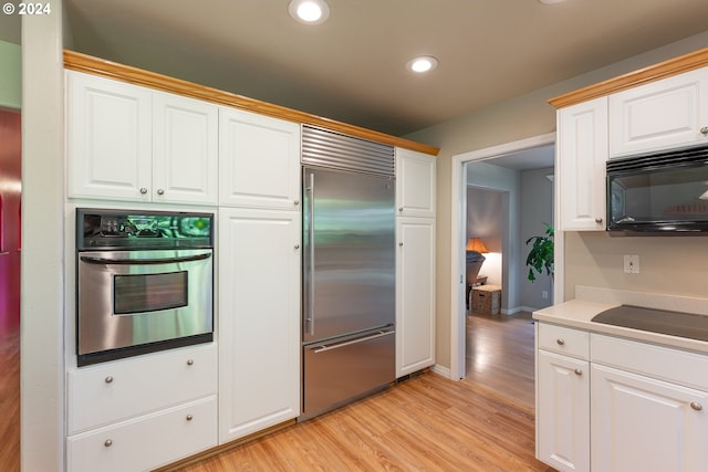 kitchen with light wood-type flooring, white cabinetry, and black appliances