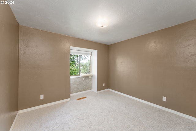 carpeted spare room featuring a textured ceiling