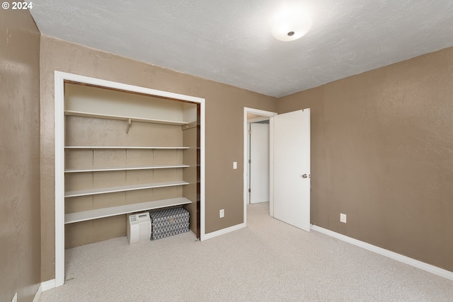 unfurnished bedroom with carpet floors, a closet, and a textured ceiling