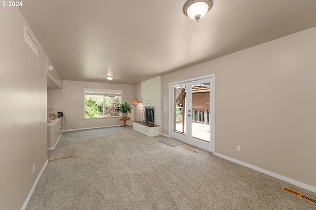 unfurnished living room featuring a fireplace and light colored carpet