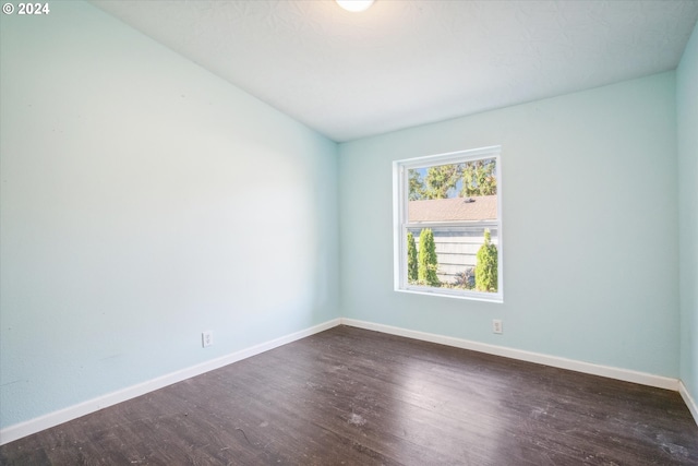 unfurnished room with dark hardwood / wood-style flooring