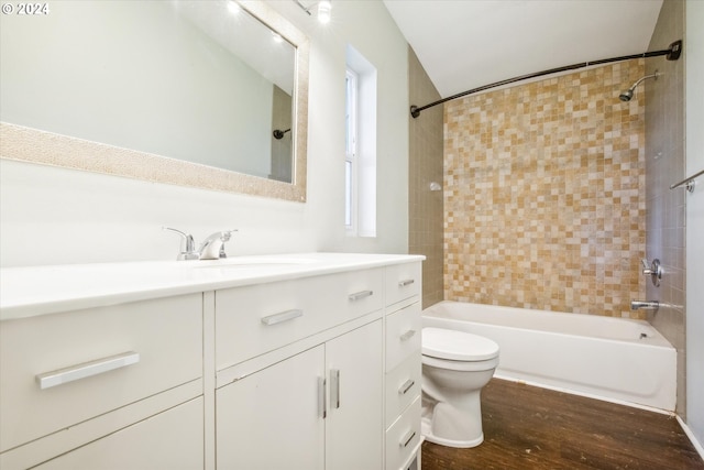 full bathroom with hardwood / wood-style floors, tiled shower / bath, toilet, and vanity