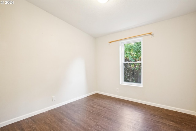 spare room featuring dark hardwood / wood-style floors and vaulted ceiling