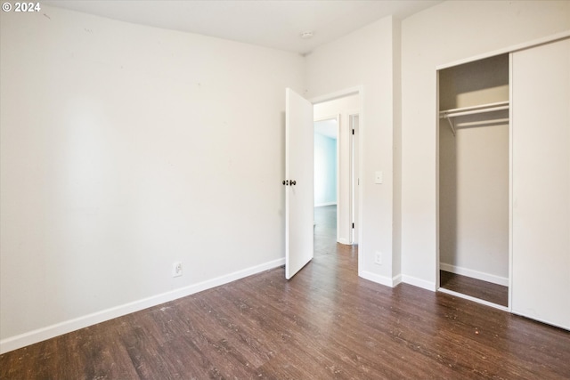 unfurnished bedroom featuring dark wood-type flooring and a closet