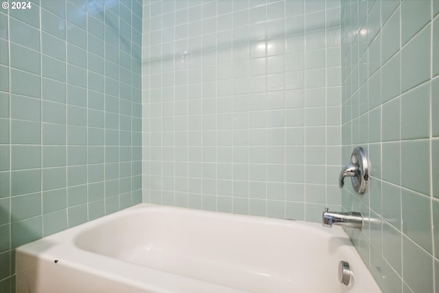 bathroom featuring tiled shower / bath