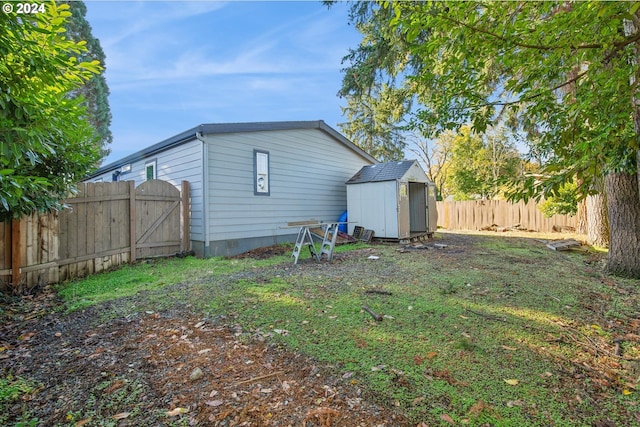 back of house with a storage unit