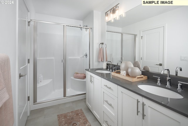 bathroom featuring tile patterned flooring, vanity, and a shower with shower door