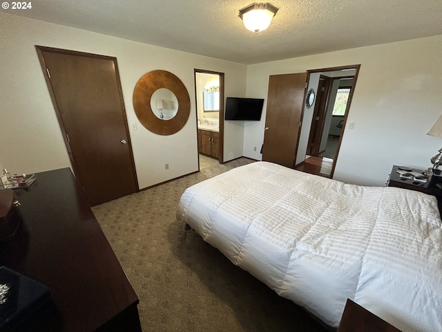 bedroom featuring a textured ceiling, light carpet, and connected bathroom