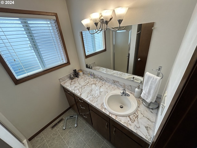 bathroom featuring tile patterned flooring, vanity, and a chandelier