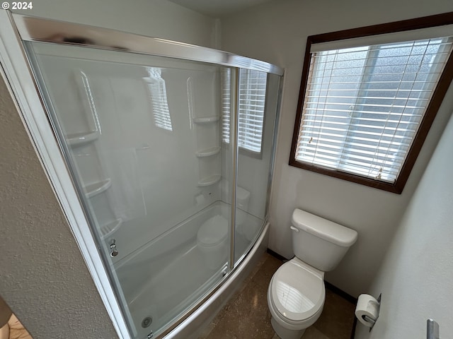 bathroom with toilet, plenty of natural light, and an enclosed shower