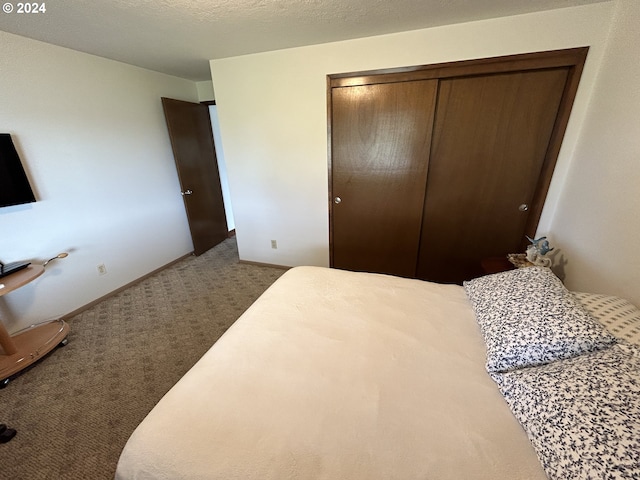 carpeted bedroom with a textured ceiling and a closet