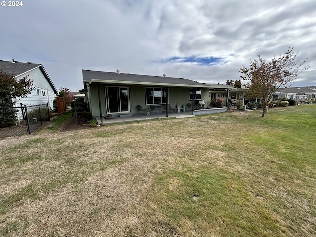 rear view of house featuring a yard and a patio