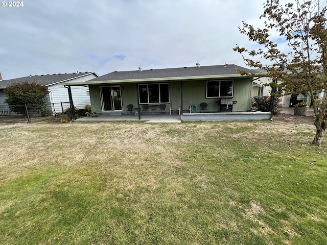 back of house with a yard and a patio