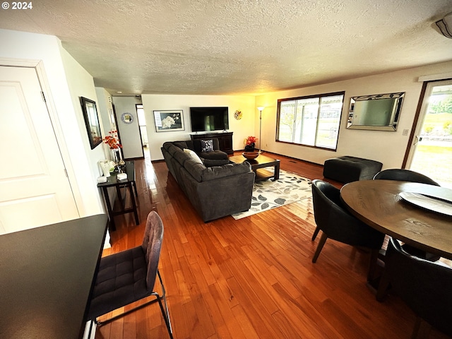 living room with plenty of natural light, wood-type flooring, and a textured ceiling