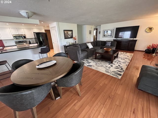 living room with light wood-type flooring and a textured ceiling