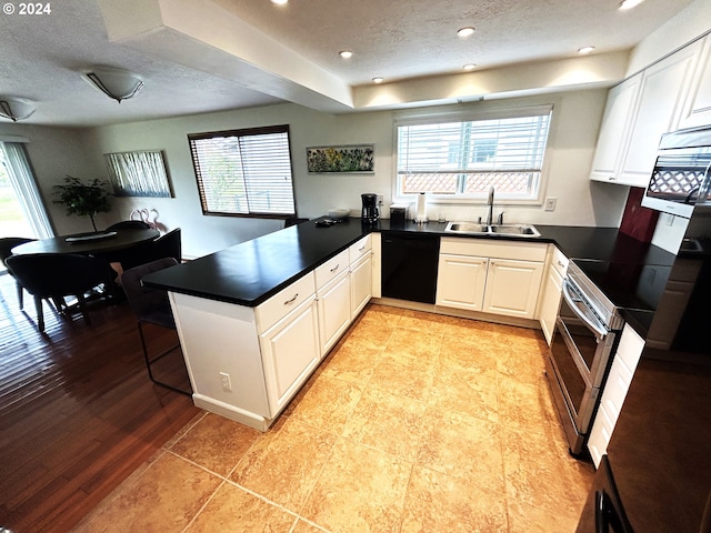 kitchen featuring white cabinetry, kitchen peninsula, dishwasher, and sink