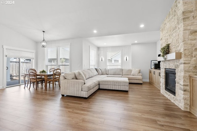 living room featuring light hardwood / wood-style flooring, a chandelier, and a fireplace