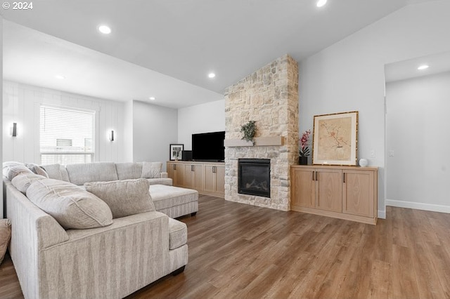 living room featuring hardwood / wood-style floors, a fireplace, and lofted ceiling