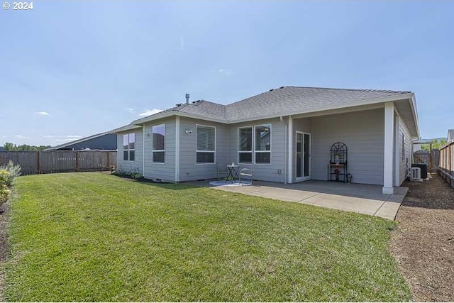 back of property with central AC unit, a patio area, and a lawn