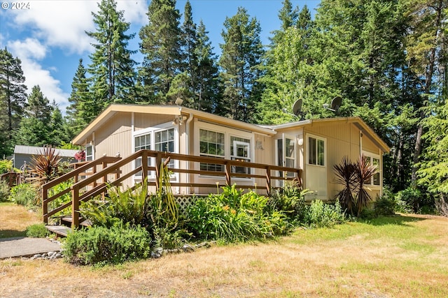 view of front of house with a front yard and a wooden deck