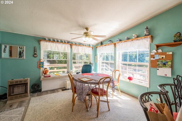 sunroom / solarium featuring lofted ceiling, heating unit, radiator heating unit, and ceiling fan