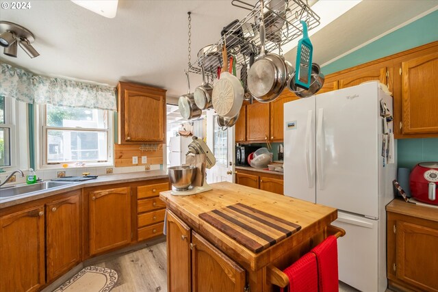 kitchen with sink, white fridge, and light wood-type flooring