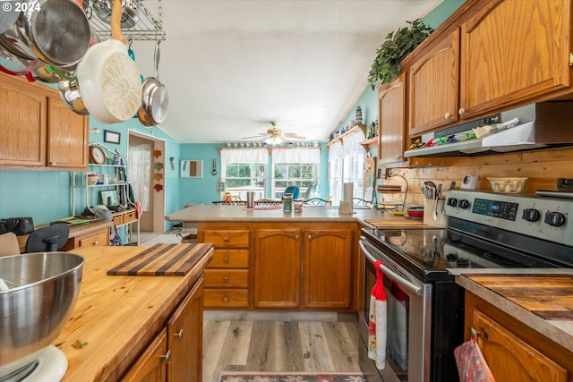 kitchen with lofted ceiling, butcher block counters, light hardwood / wood-style floors, and stainless steel electric range