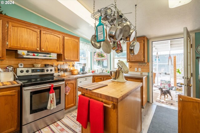 kitchen featuring sink, a center island, light wood-type flooring, white appliances, and backsplash