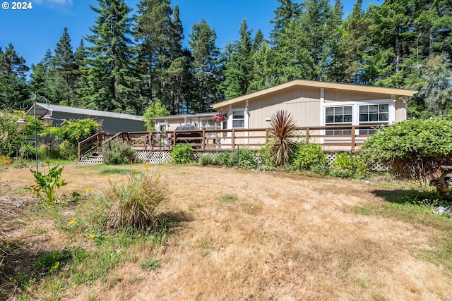 exterior space with a deck and a lawn